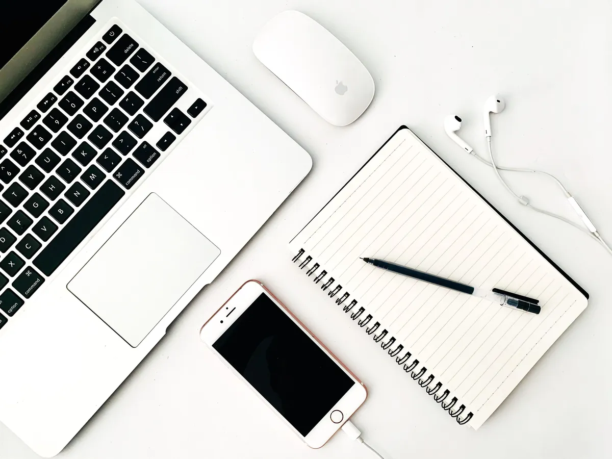 Laptop, smartphone and notebook on a minimalist desk workspace