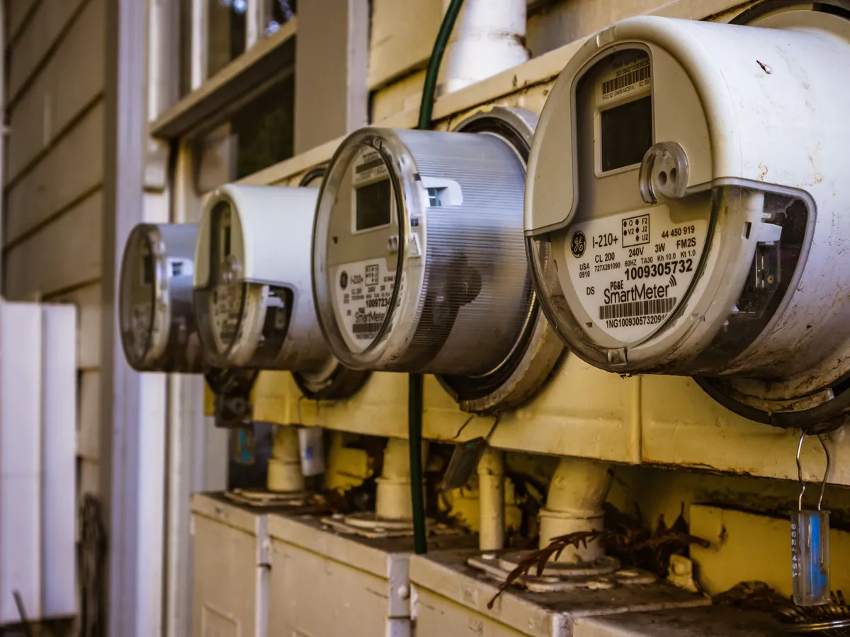 Row of residential smart electricity meters mounted on a house exterior wall