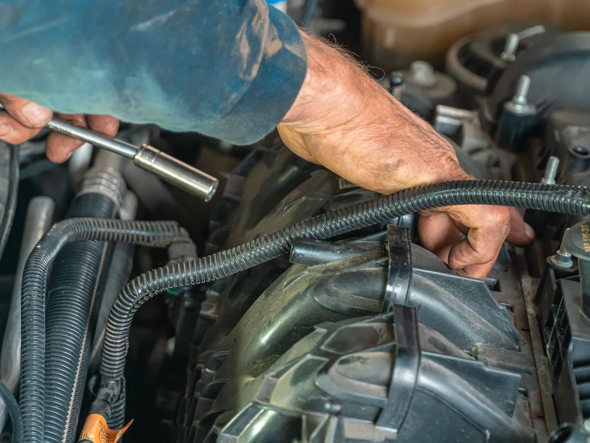 Mechanic working on a car engine in a garage