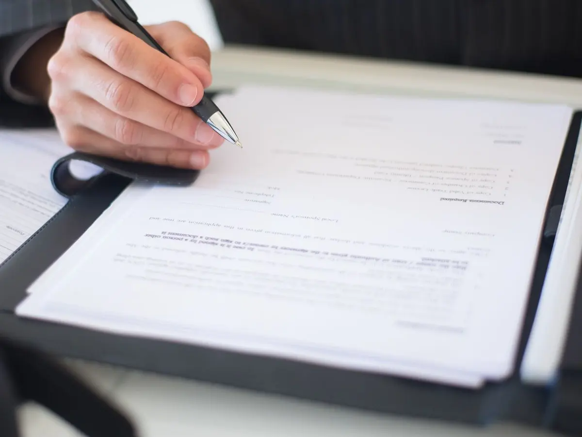 Homeowner signing a contractor estimate on a clipboard
