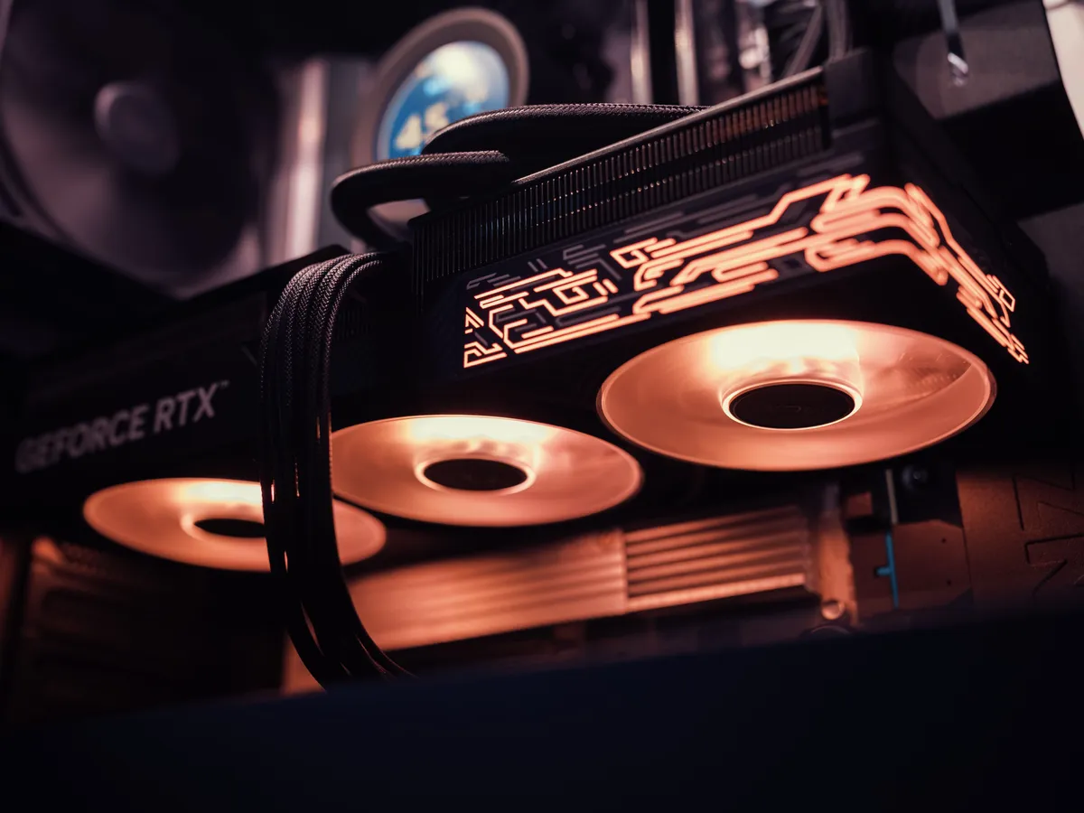 Close-up of a GeForce RTX graphics card with glowing orange fans inside a PC case