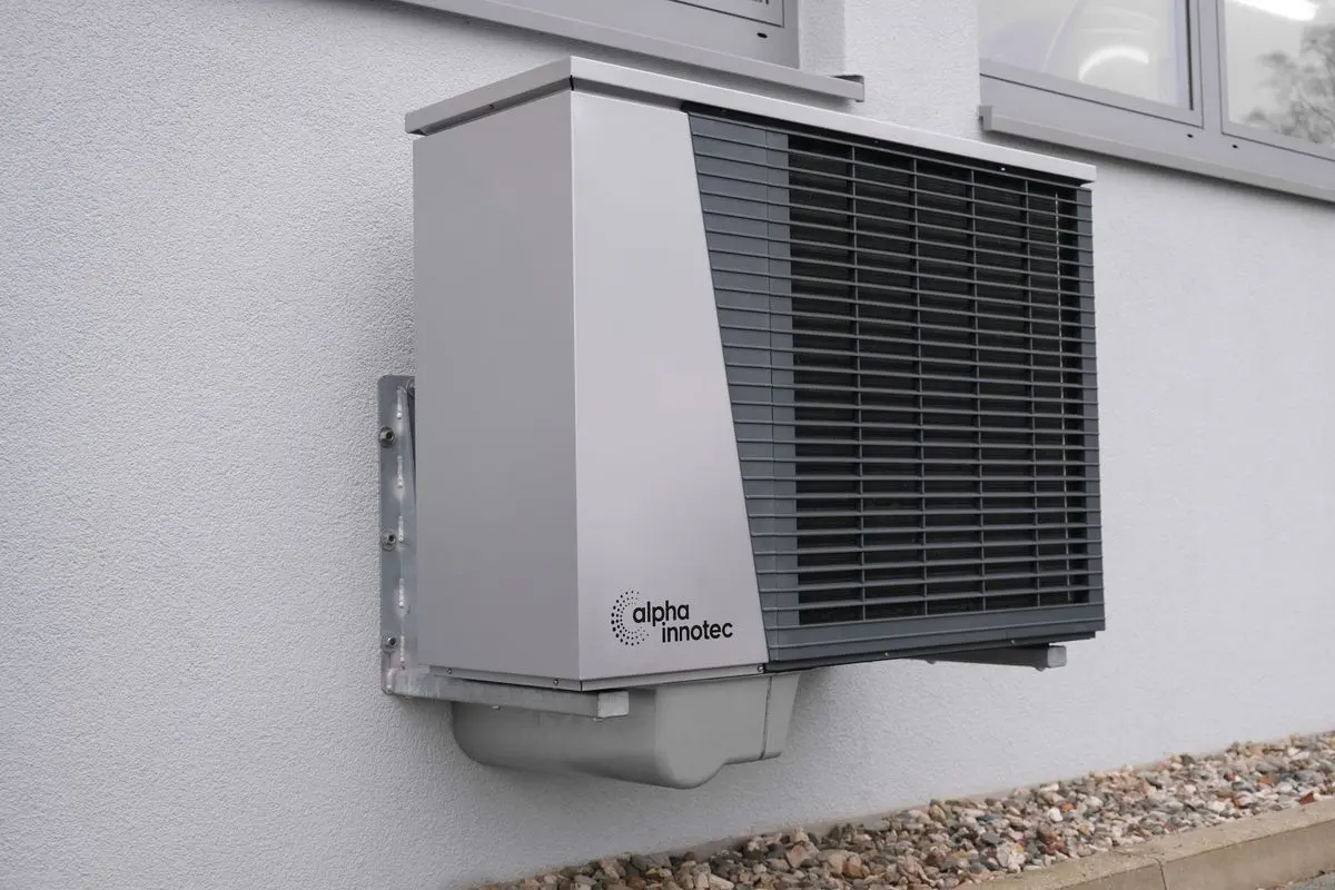 Air-source heat pump outdoor unit mounted on an exterior wall