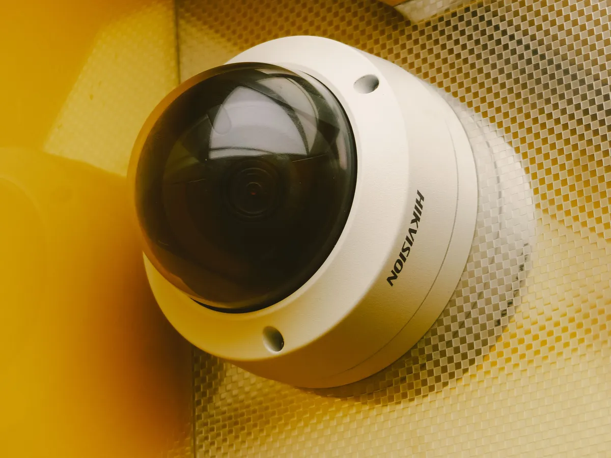 Close-up of a white dome surveillance camera on a wall