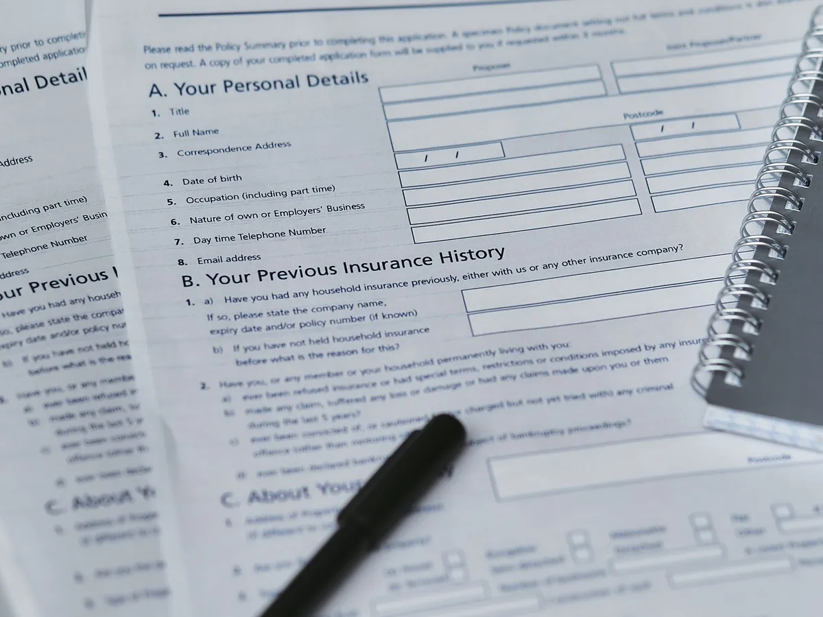 Home insurance policy form and notebook laid flat on a table