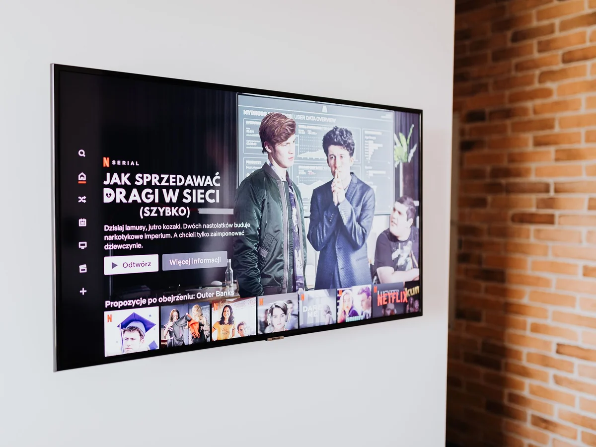 Flat-screen TV on a white wall above a media console in a living room