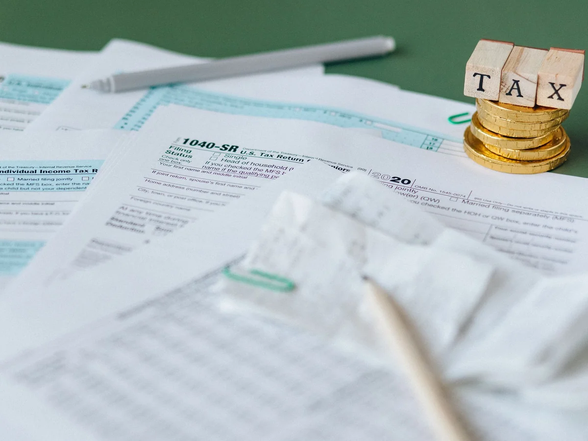Property tax forms, a calculator and wooden TAX blocks on a desk