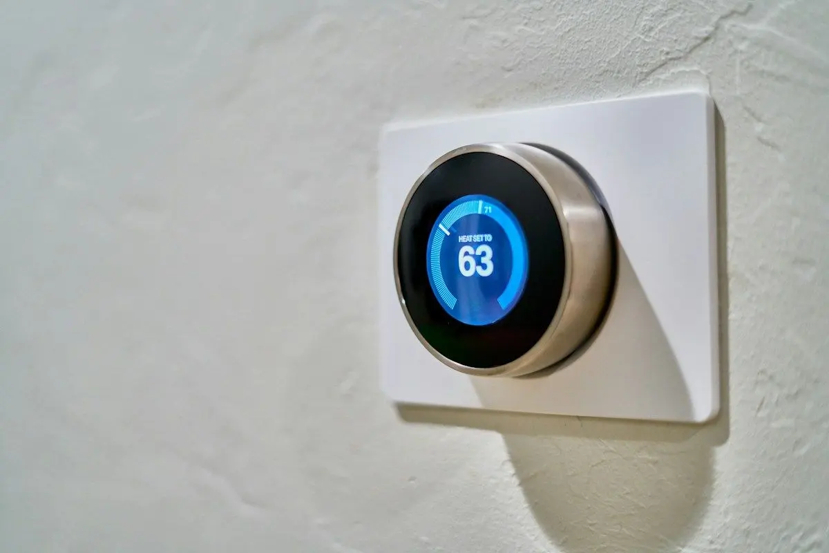 Smart thermostat on a wall showing 63 degrees
