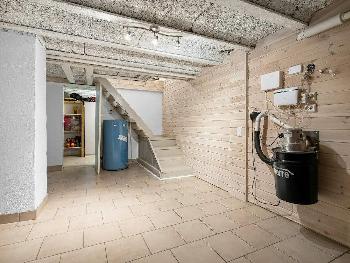 Finished basement with a wall-mounted pump and utility equipment