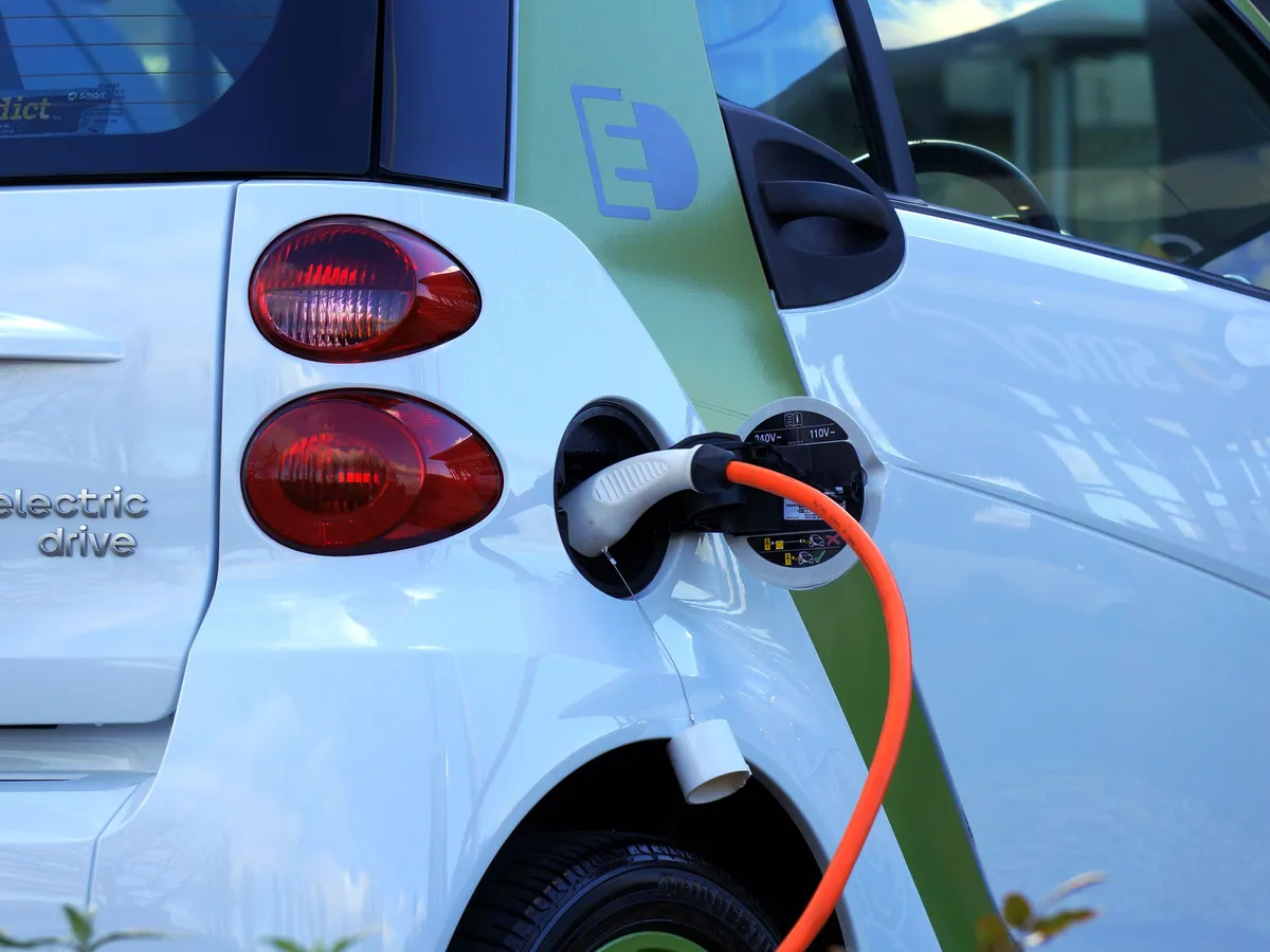 Close-up of an electric car being charged at a public charging station
