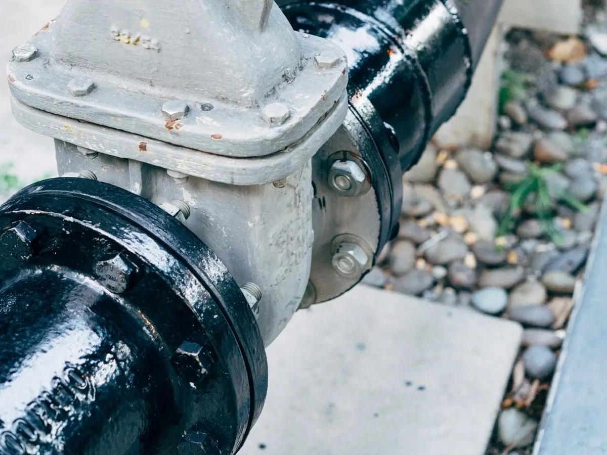 Black iron water main pipe and valve at a home connection