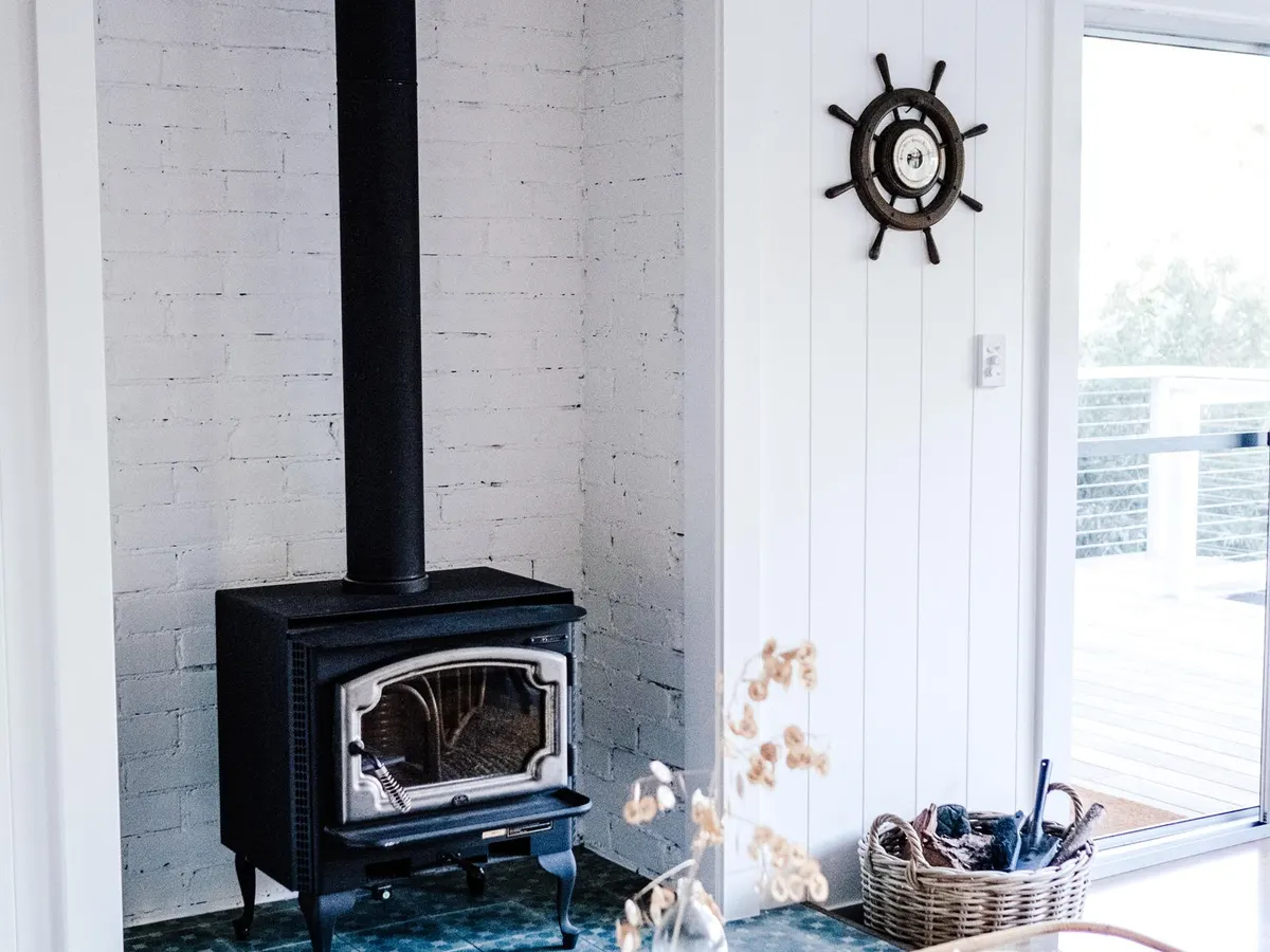 Black wood-burning stove on a tiled hearth in a white living room